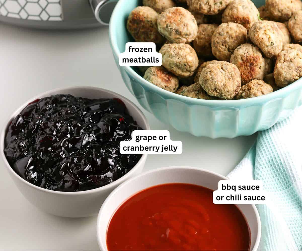 Easy 3-ingredient Grape Jelly Meatballs made in the crockpot or on the stovetop. Sweet, savory, and gone in minutes at every party! A bowl of frozen meatballs, a bowl of grape or cranberry jelly, and a bowl of BBQ or chili sauce are arranged on a white surface with labels identifying each item.