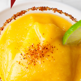 Up close image of a mango margarita with tajin rim.