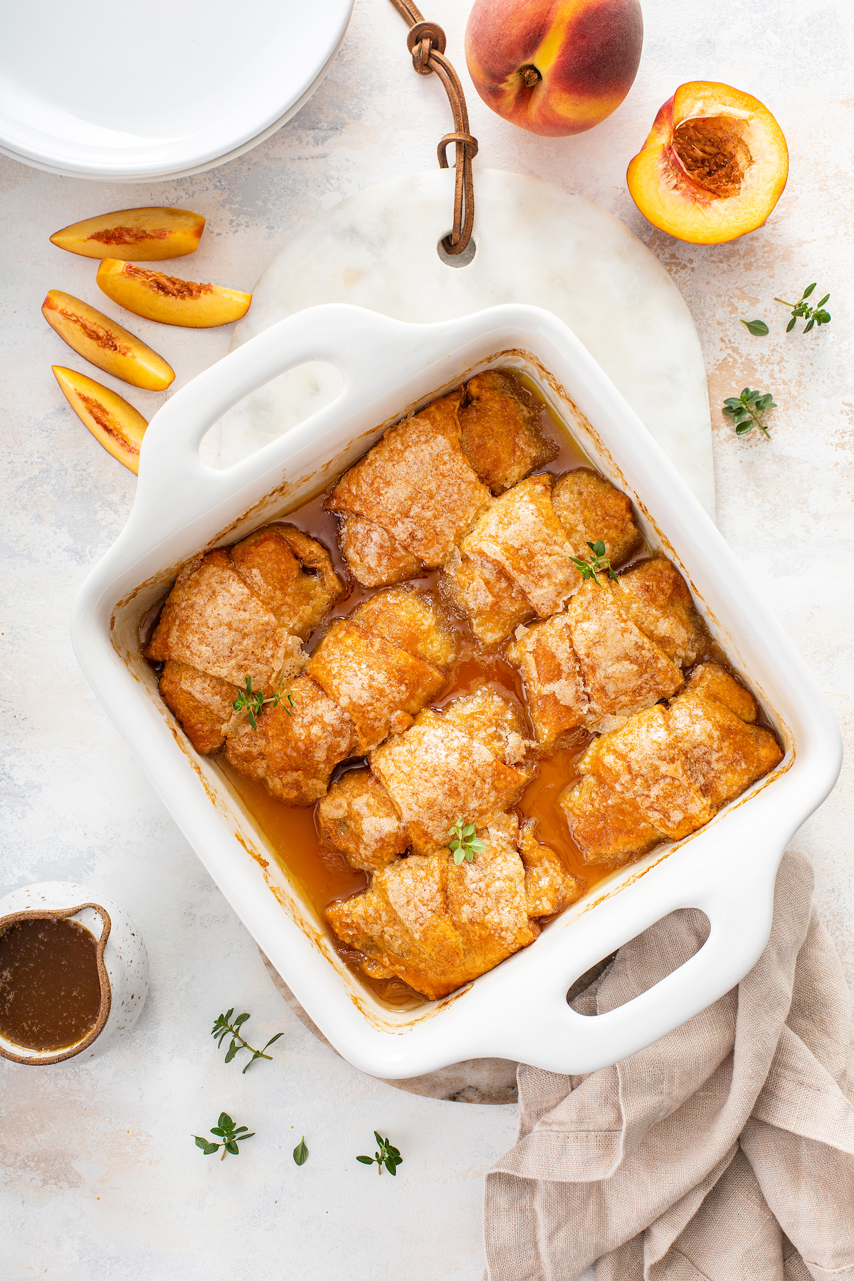 Overhead shot of baked peach crescents in a square baking dish.