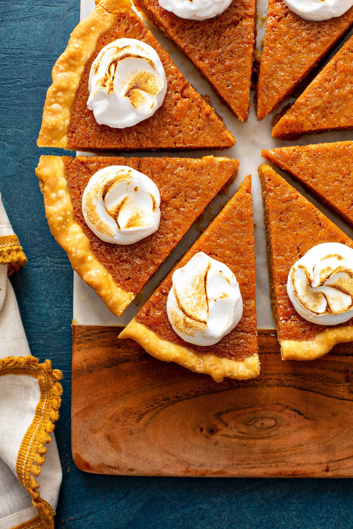 Sweet potato pie on a cutting board sliced into pieces.
