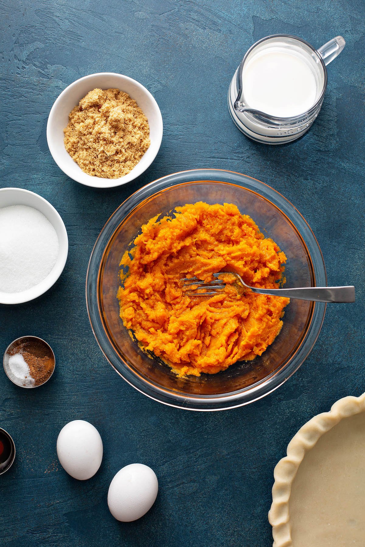 Ingredients for pie in bowls on a blue background.