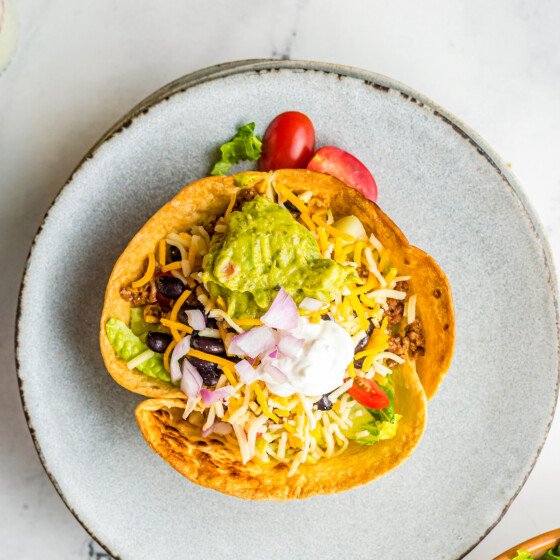 A homemade tortilla bowl filled with salad ingredients.