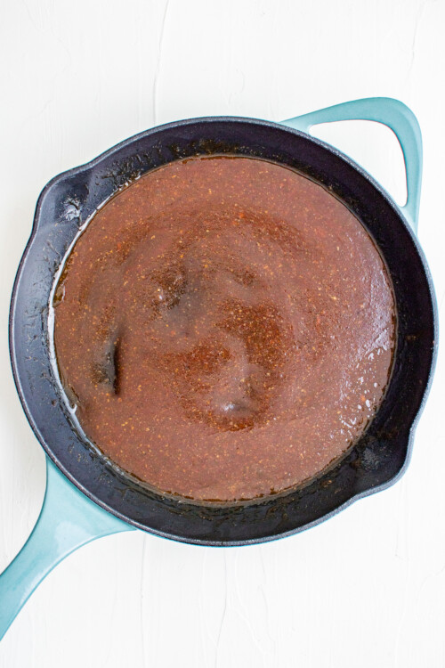 Brown sauce cooking in a heavy skillet.