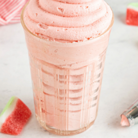 Watermelon frosting piped into a glass jar.