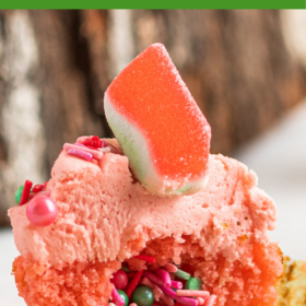 Up close image of watermelon cupcake with surprise sprinkle filling falling out.