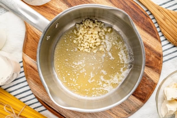 Butter and garlic being sautéed together in a sauce pan.