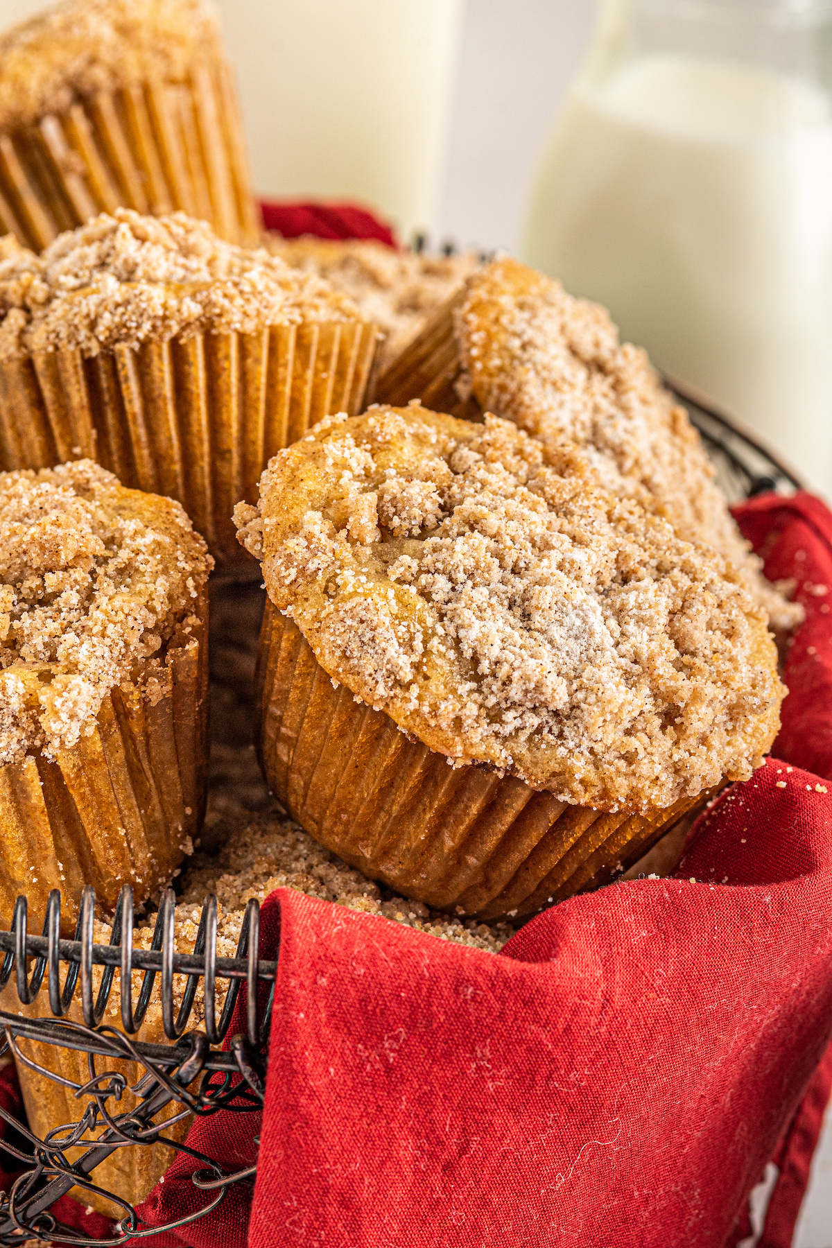Close-up shot of muffins in a wire basket with a red cloth napkin.