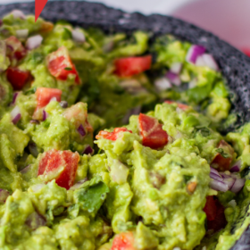 Up close image of the best guacamole in a Molcajete.