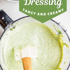 Cilantro lime dressing in a food processor with a spatula in it.