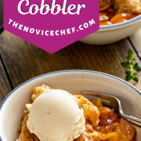 Homemade peach cobbler in a bowl with vanilla ice cream on top and a spoon.