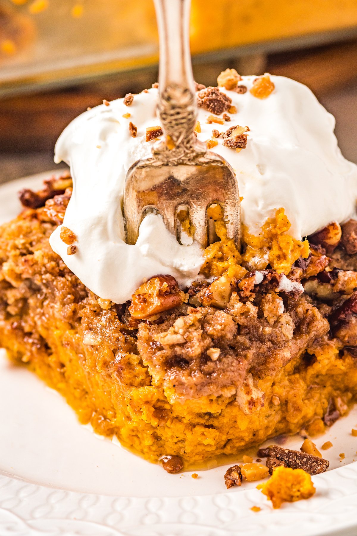 A rich pumpkin dessert with a pecan topping and ice cream garnish.