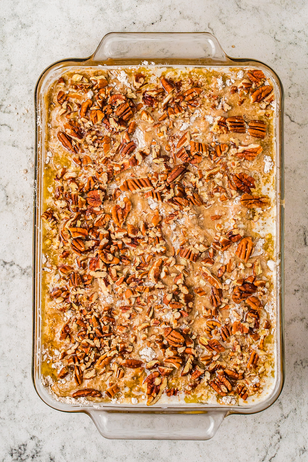 An unbaked dump cake topped with nuts and toffee bits.