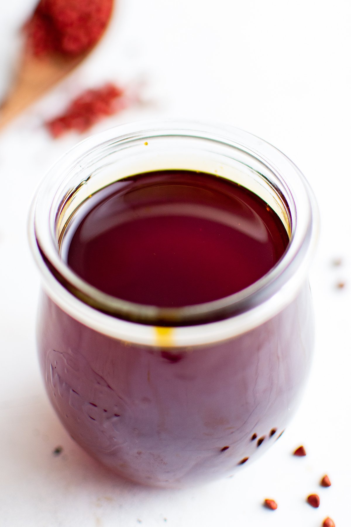 A small glass jar of red-gold oil.