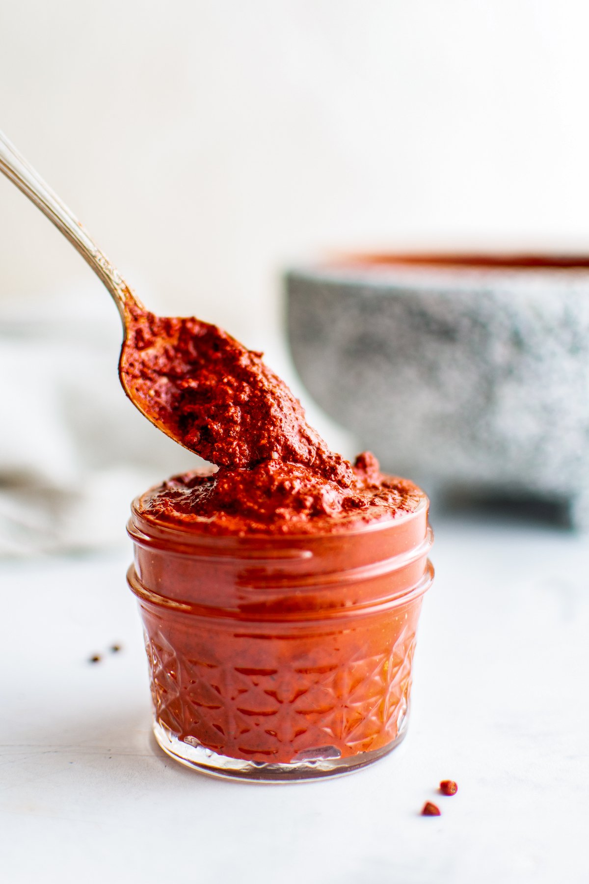 achiote paste which is a bright red meat rub in a small mason jar