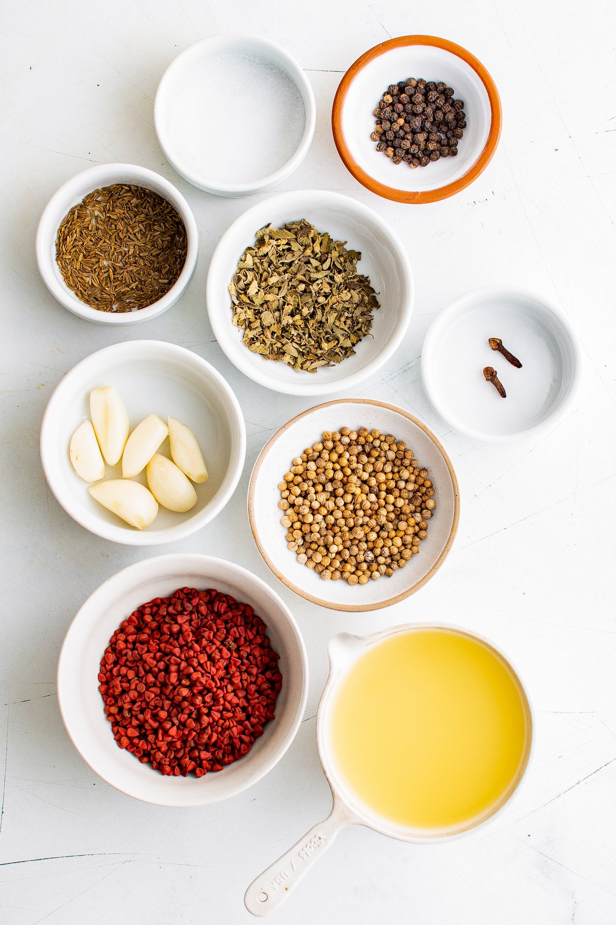 prep ingredients in small bowls to make achiote paste like dried spices, orange juice, and garlic