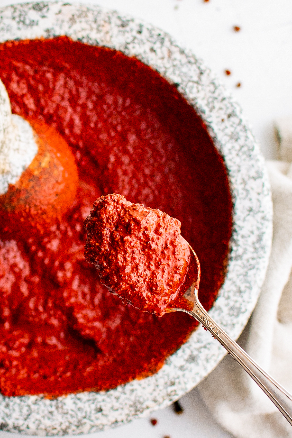 A bright red spice-based meat rub in a mortar and pestle