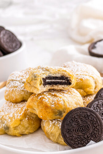 a bite out of an Oreo cookie wrapped in crescent dough and baked to a golden brown color