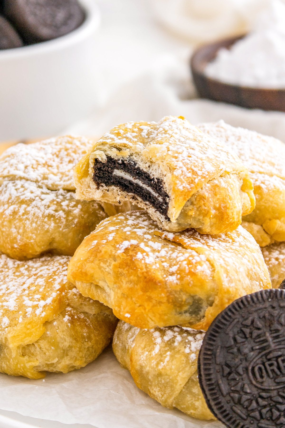 a bite out of an Oreo cookie wrapped in crescent dough and baked to a golden brown color