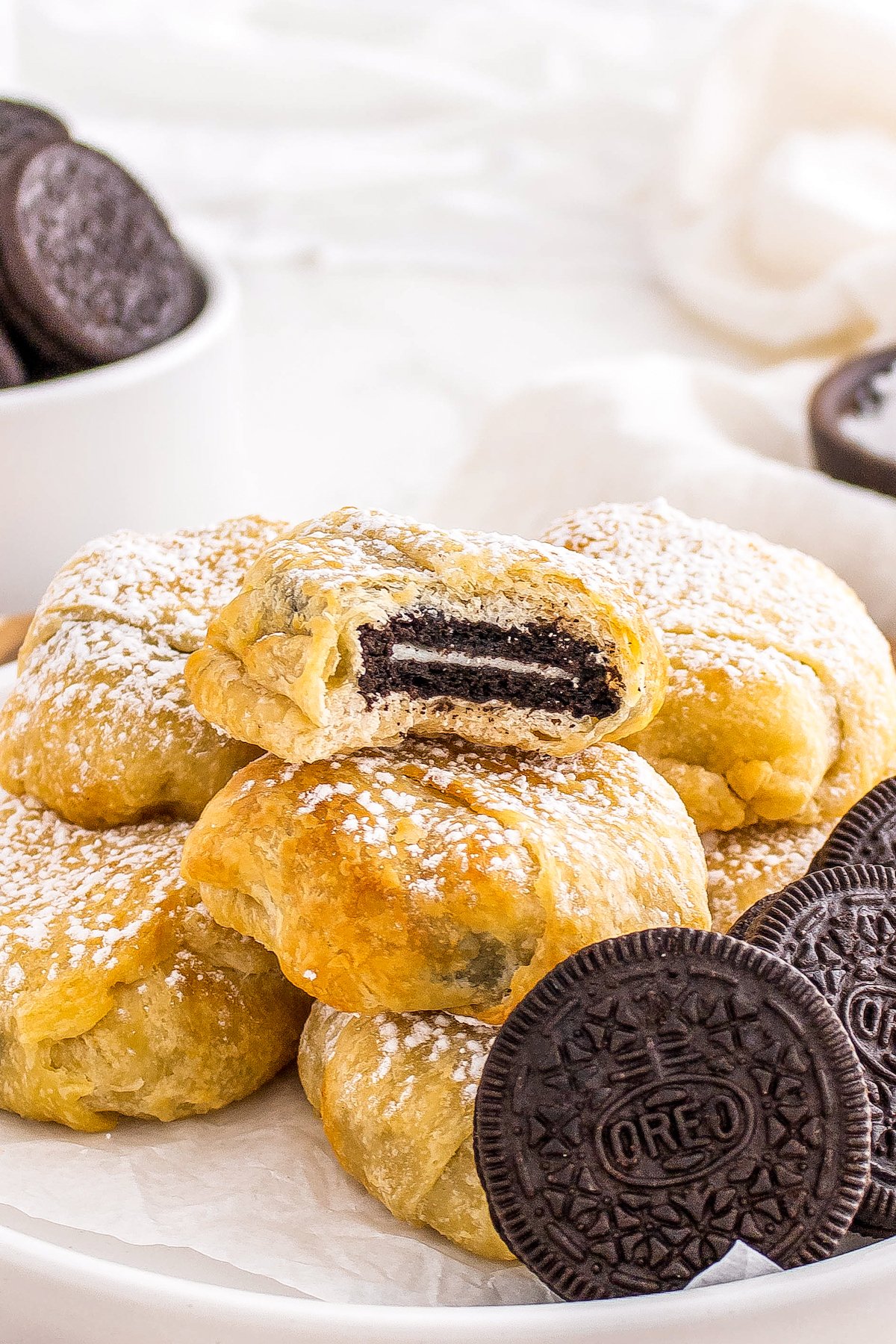 a bite out of an Oreo cookie wrapped in crescent dough and baked to a golden brown color