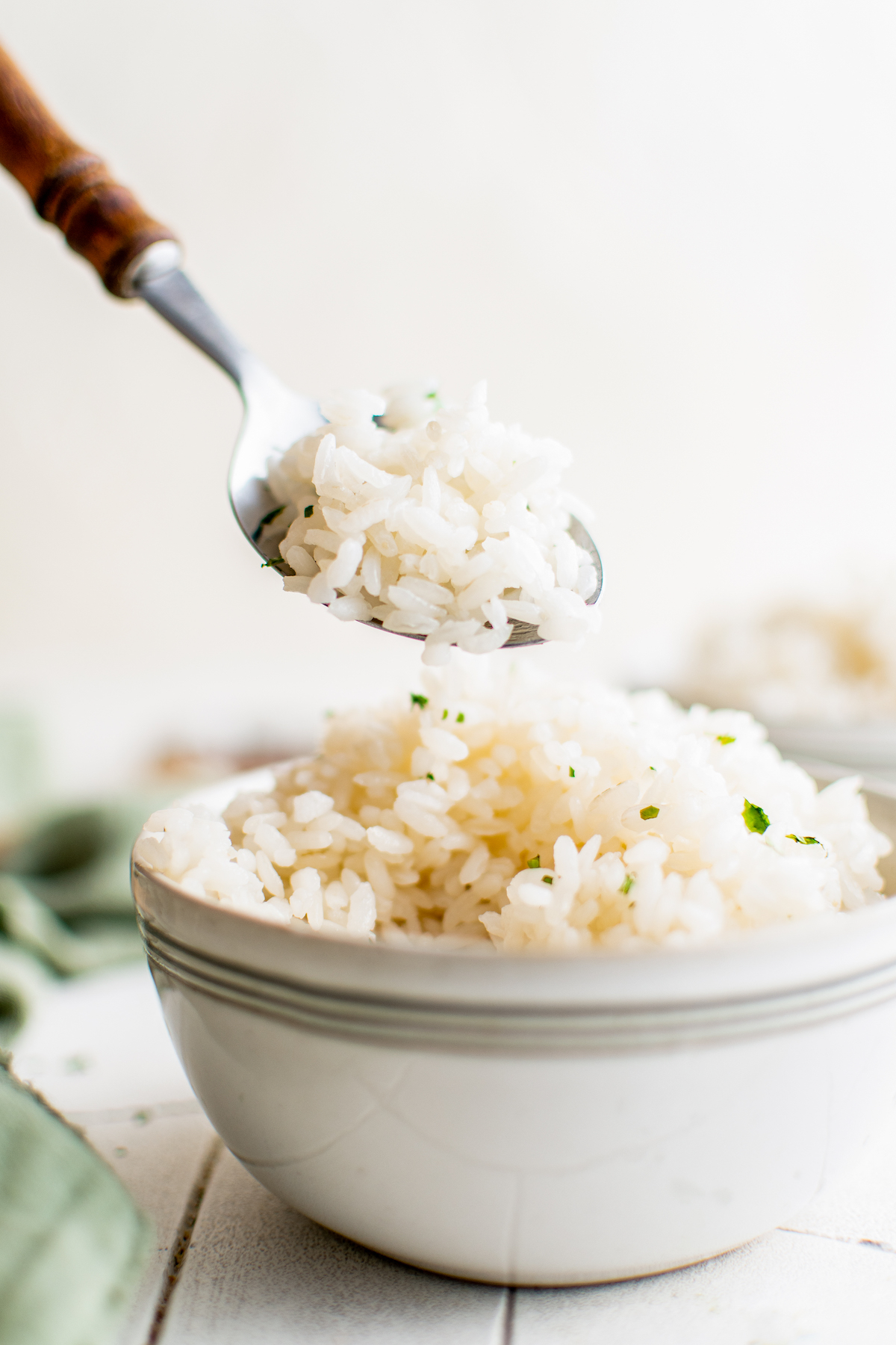 a bowl of cooked rice with a spoon taking out a bite full