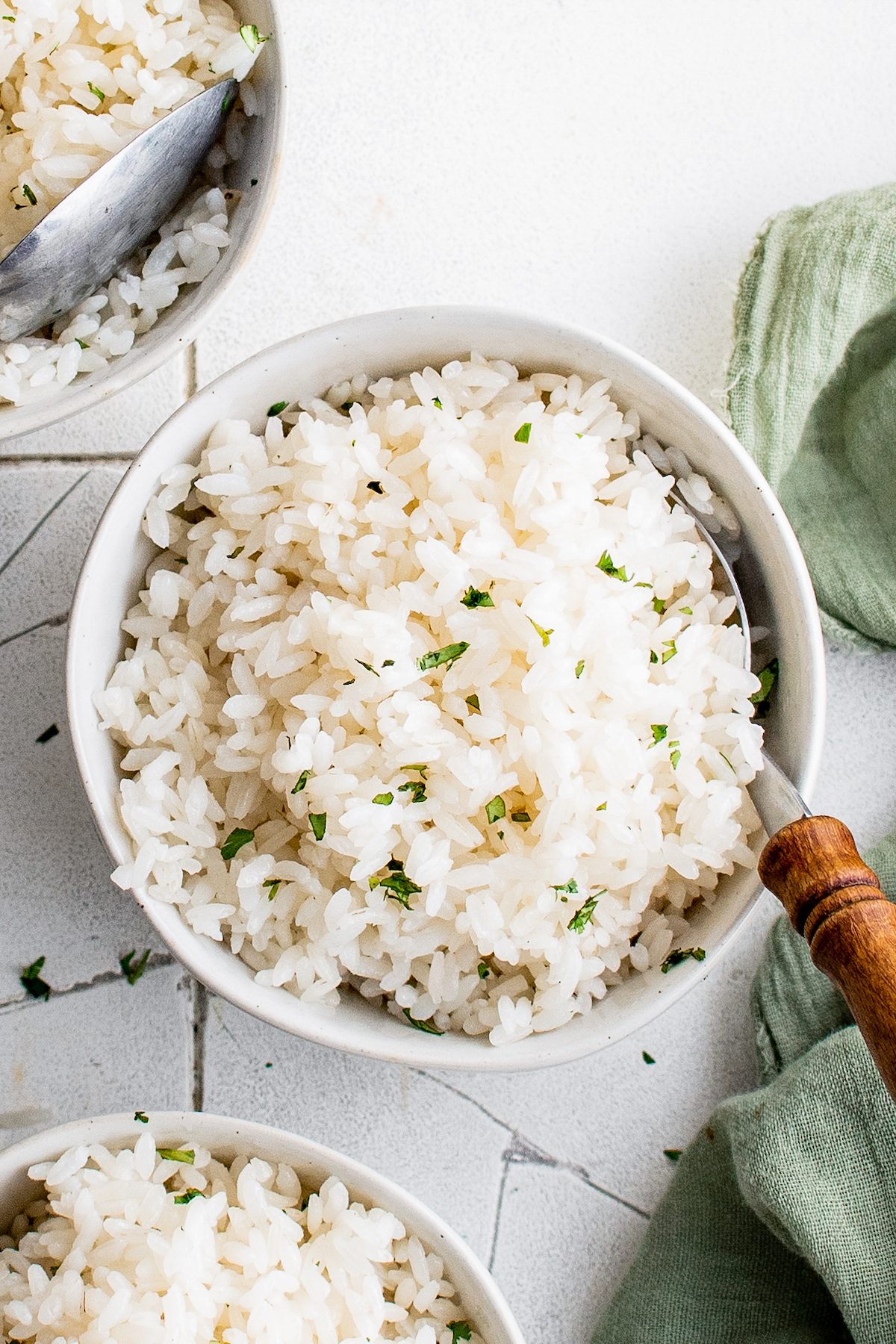 fluffy white rice in a bowl garnished with fresh herbs