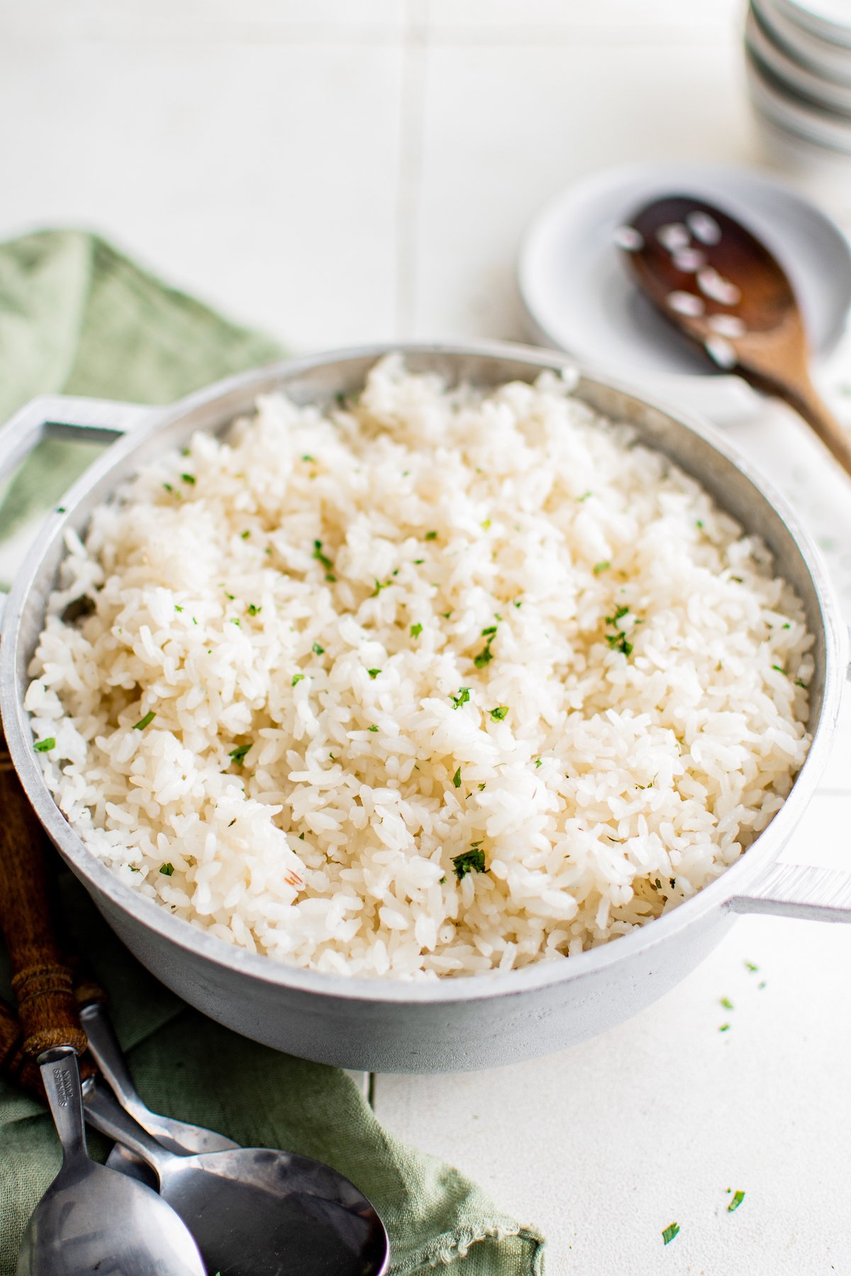 fluffy white rice in a bowl garnished with fresh herbs