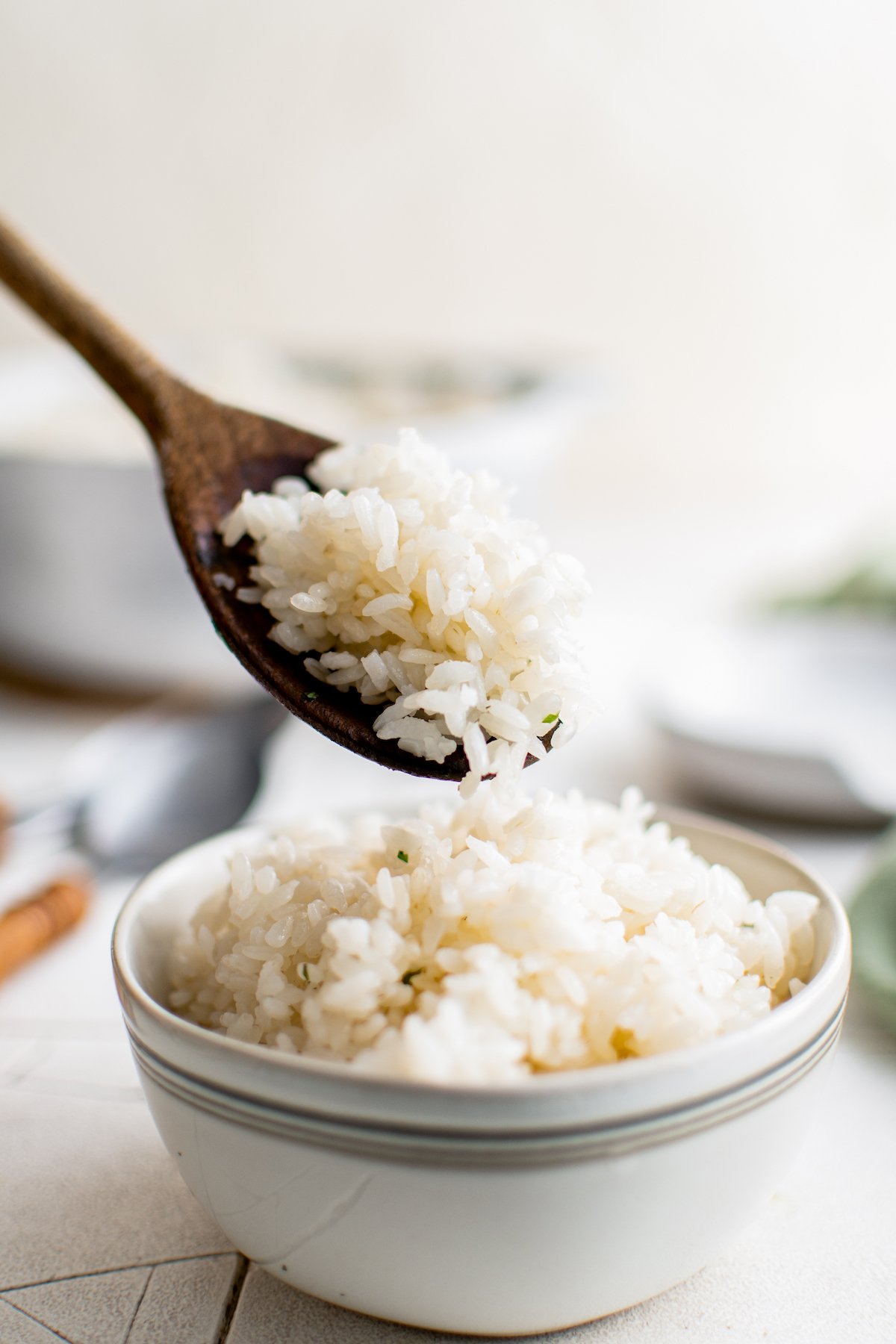 a bowl of cooked rice being filled with a wooden spoon