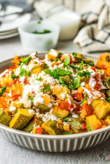 A bowl of homemade calabacitas with corn, tomatoes, and queso fresco.