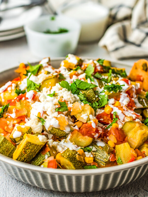 A bowl of homemade calabacitas with corn, tomatoes, and queso fresco.