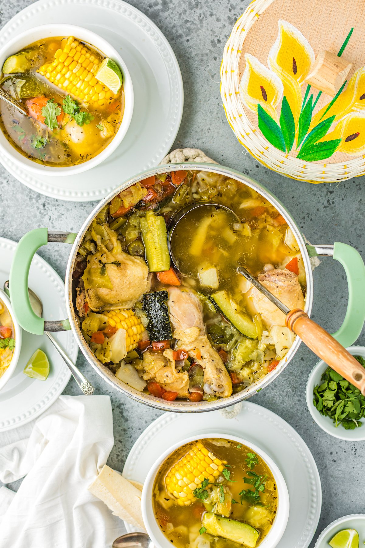 A large pot of Mexican chicken soup being ladled into bowls for serving.