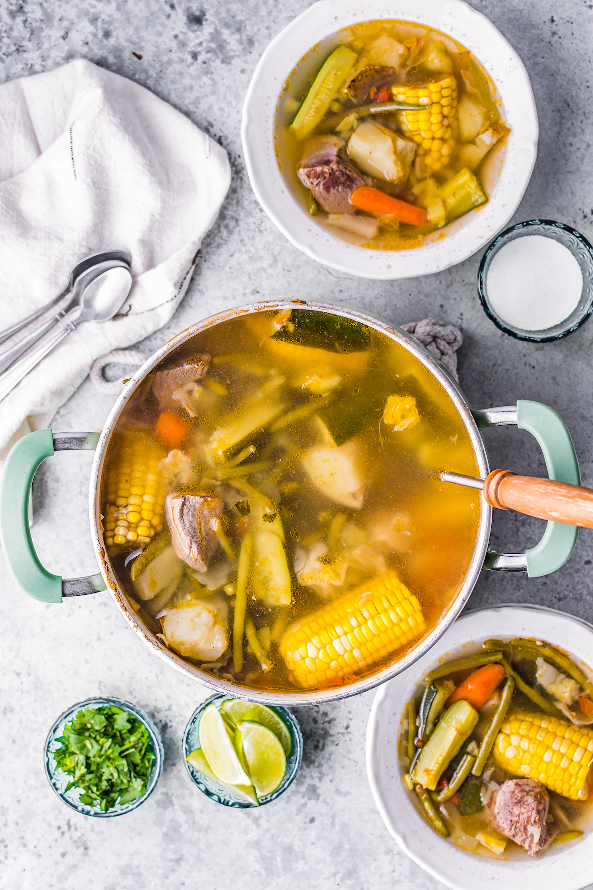 Simmering Caldo de Res, or beef soup, containing beef, corn on the cob, zucchini, and other vegetables