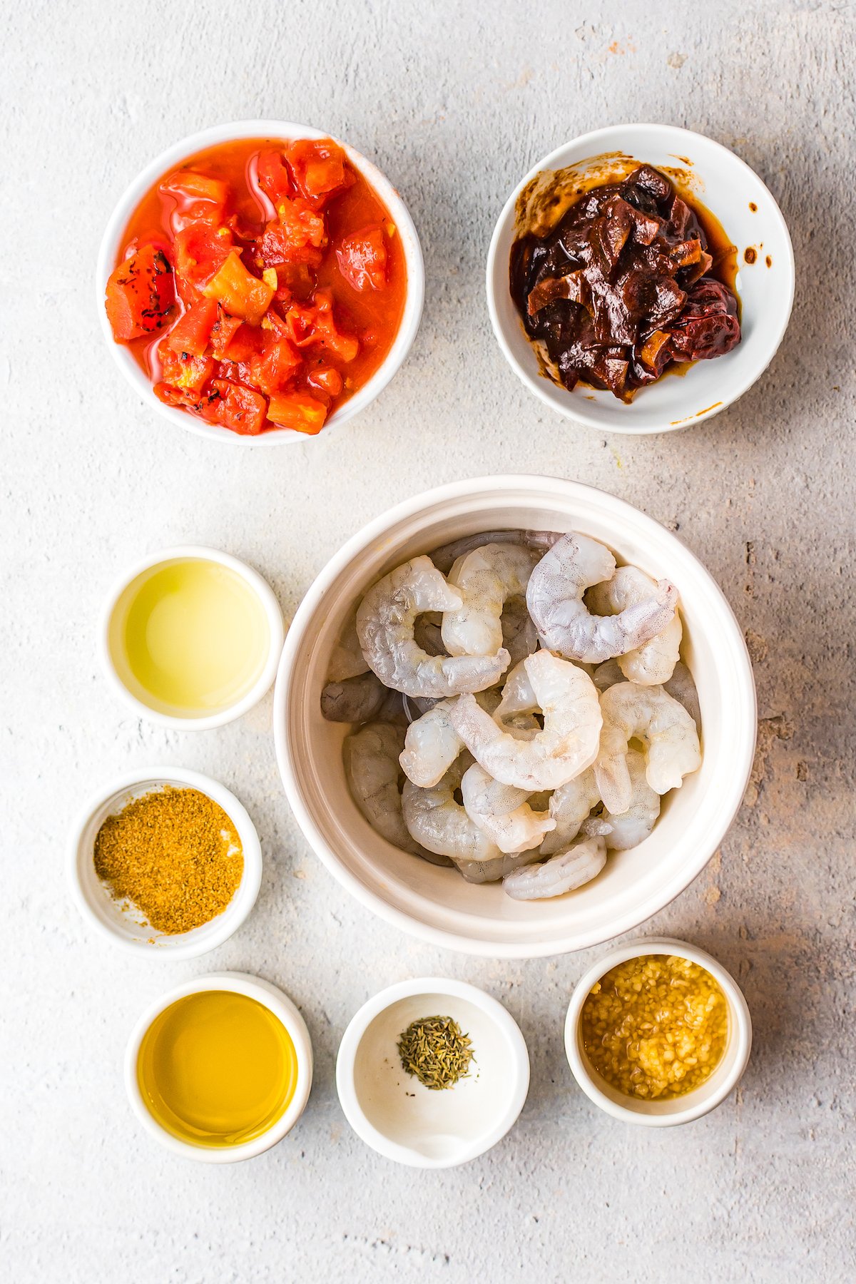 From top left: Fire-roasted tomatoes, chipotle peppers in adobo sauce, lime juice, raw shrimp, cumin, olive oil, salt and pepper, dried thyme.