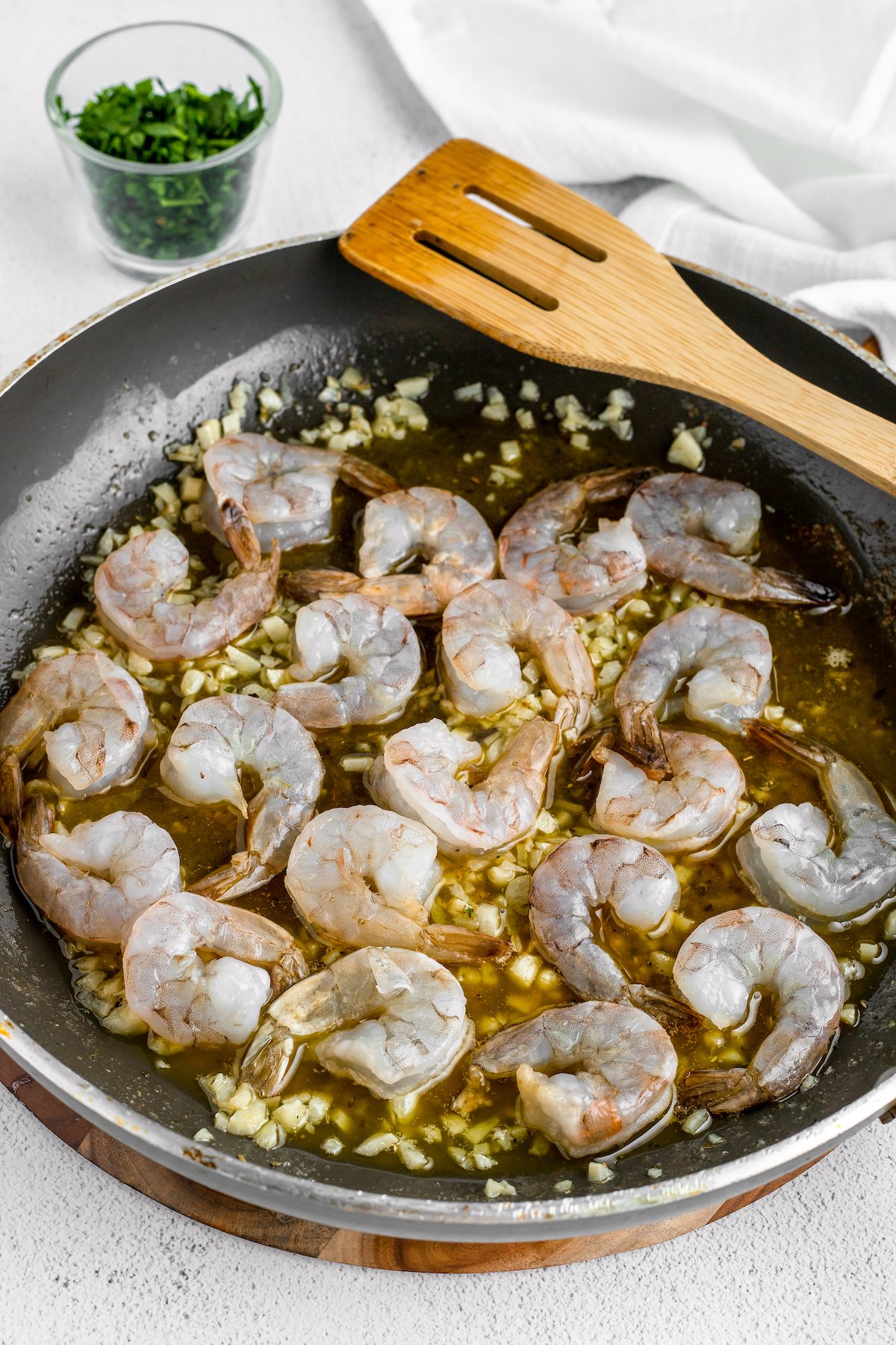 Shrimp sauteing in a skillet with garlic.