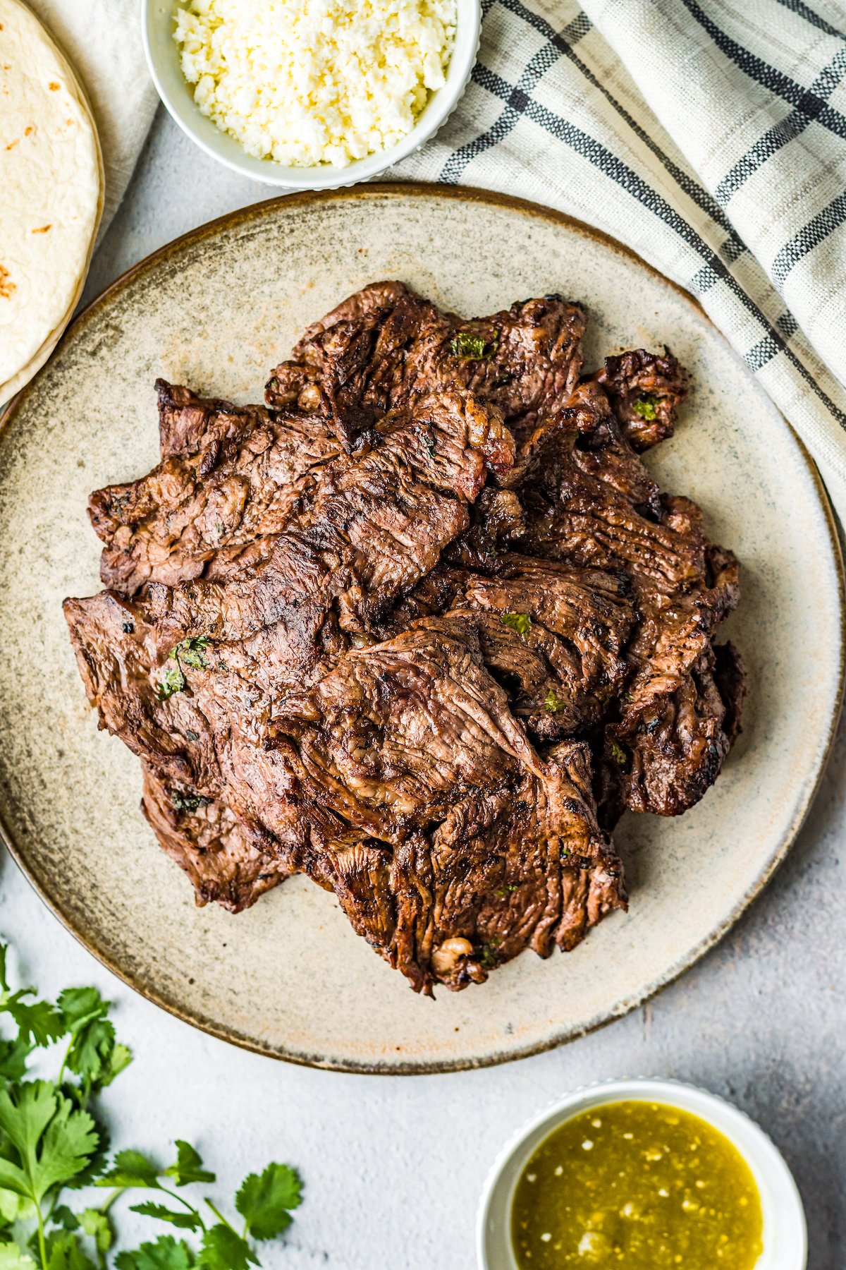 A platter of cooked flank steak pieces.