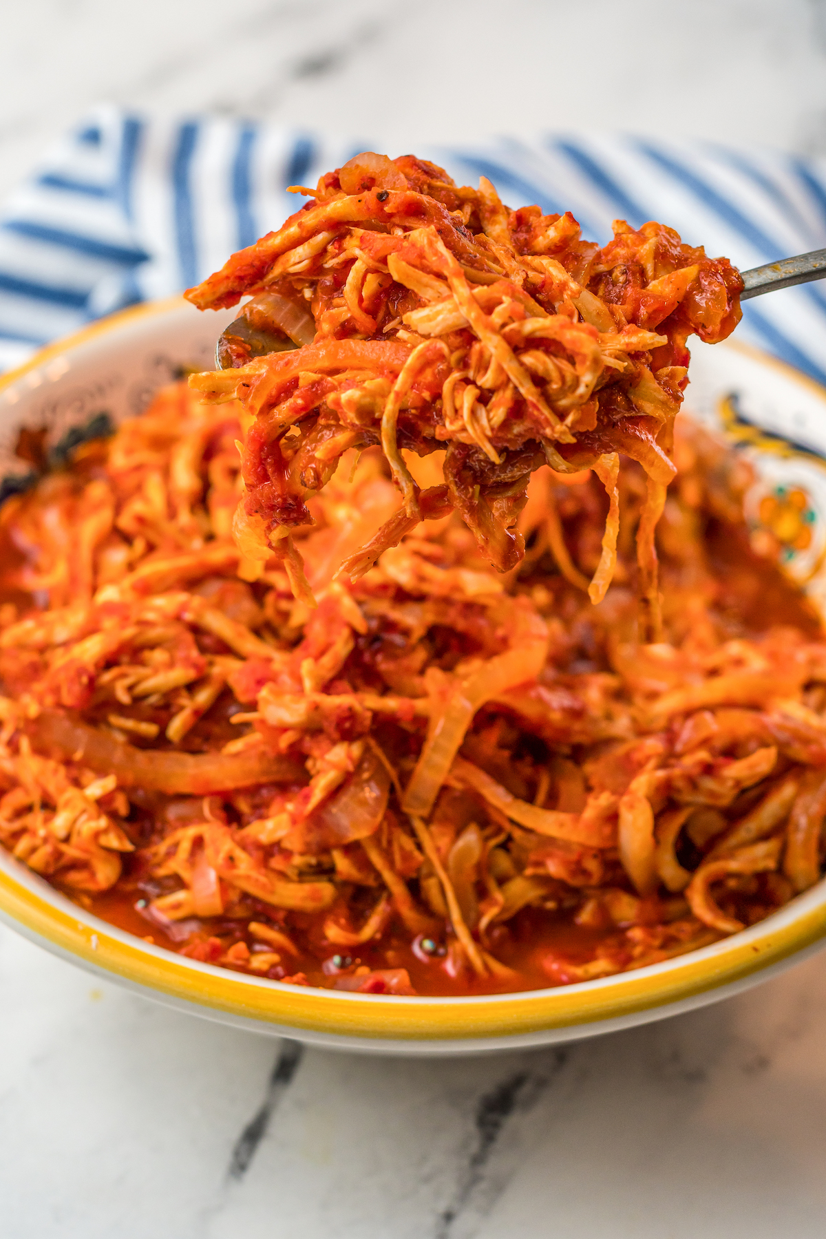 Shredded chicken in a red sauce in a bowl