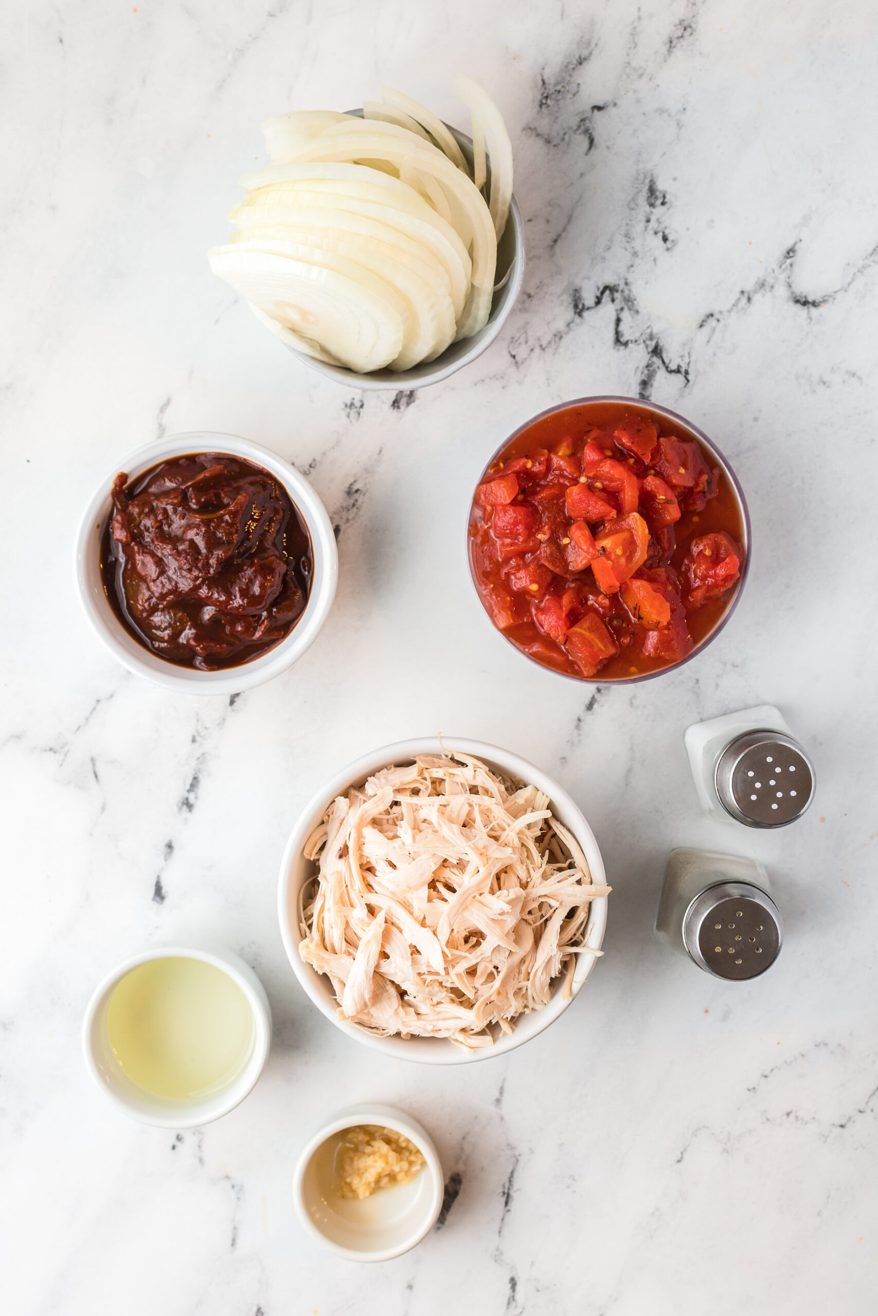 invidividual prep bowls with onions, chipotle peppers, roasted tomatoes, shredded chicken, lime juice, and spices