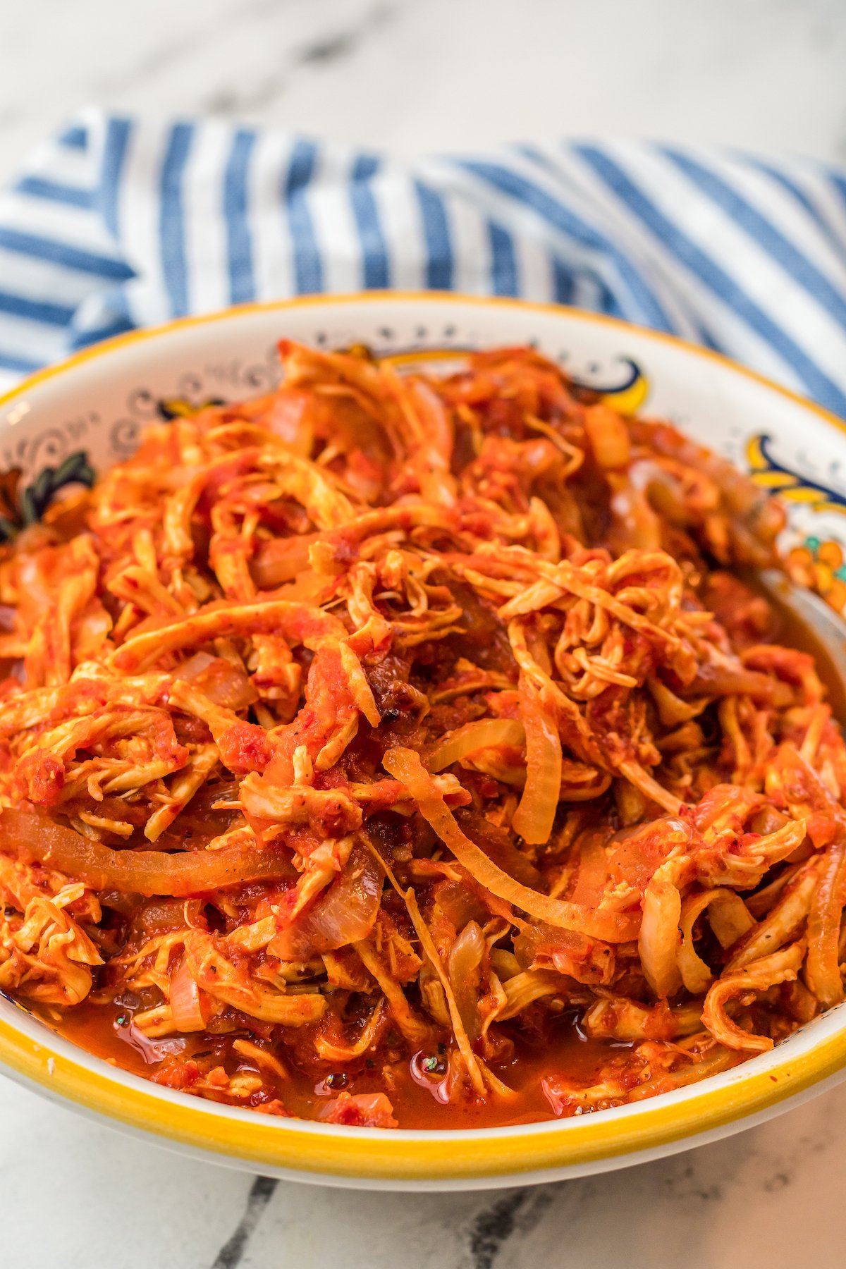 Shredded chicken in a red sauce in a bowl