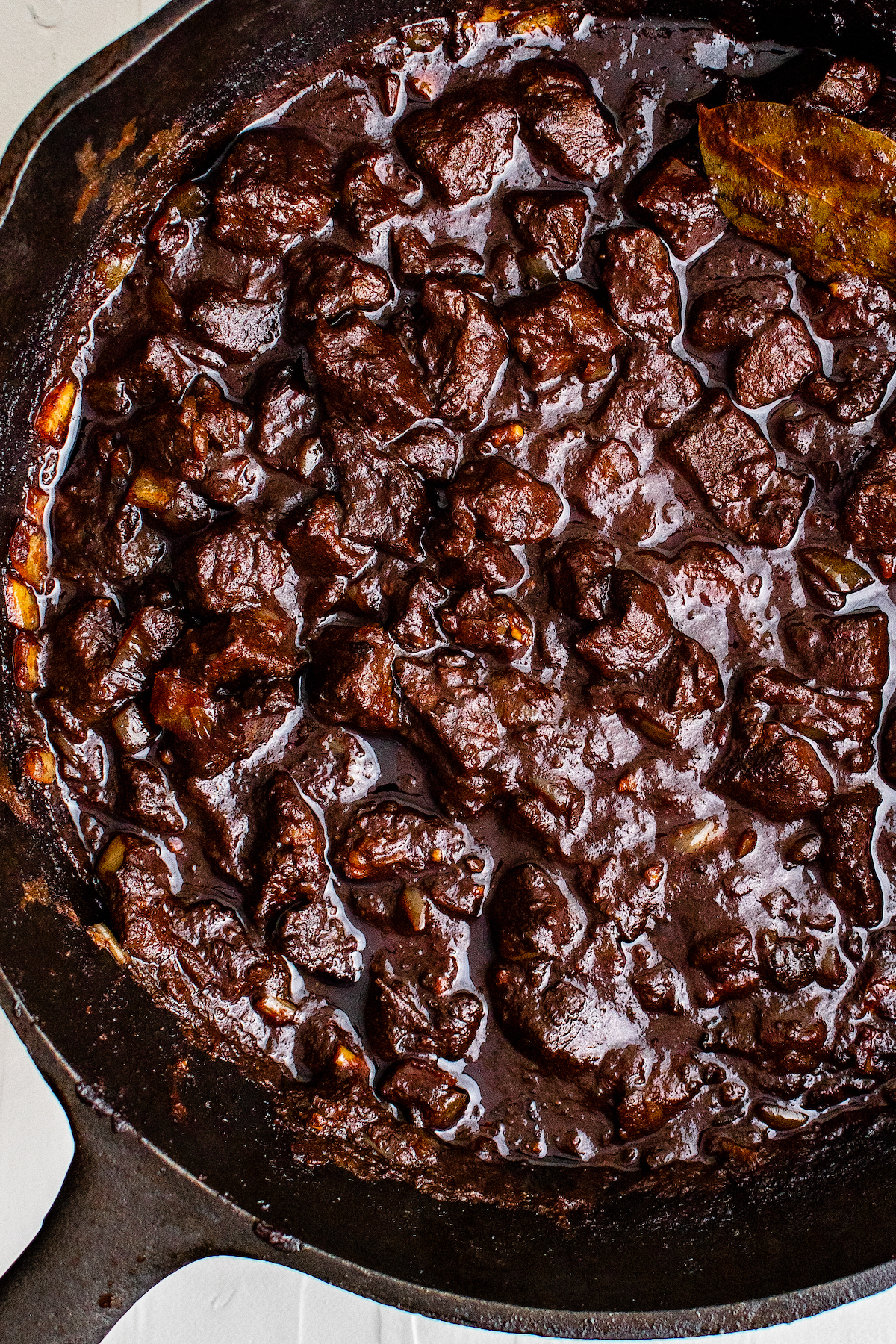  Mexican beef stew made with beef, dried chili peppers, and spices in a cast iron skillet