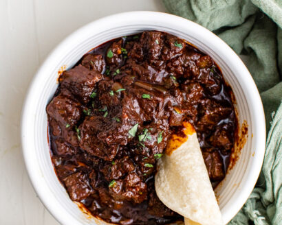 Beef in a red chili based sauce with a tortilla dipped into it