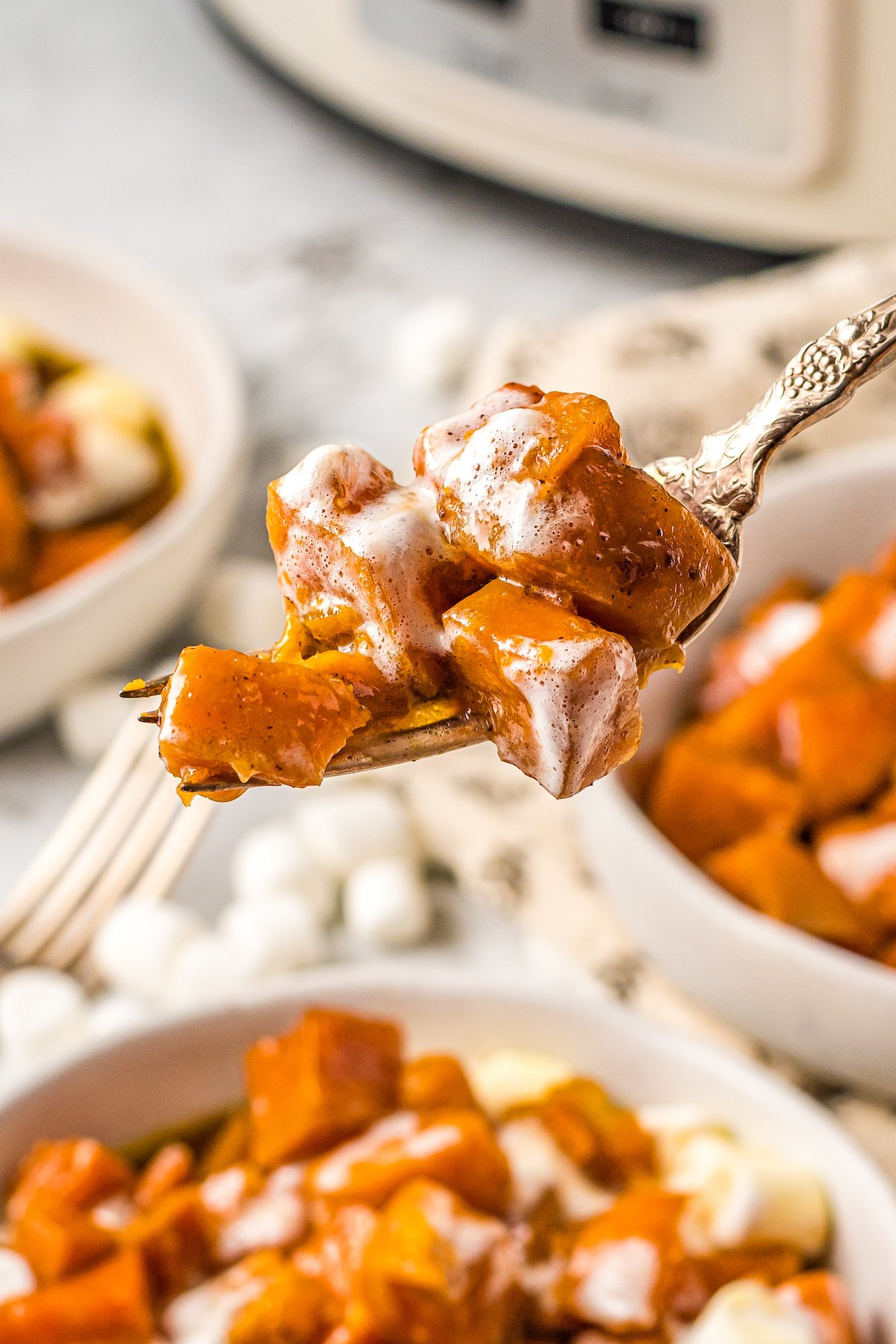 cubed sweet potatoes with melted mini marshmallows on top on a fork