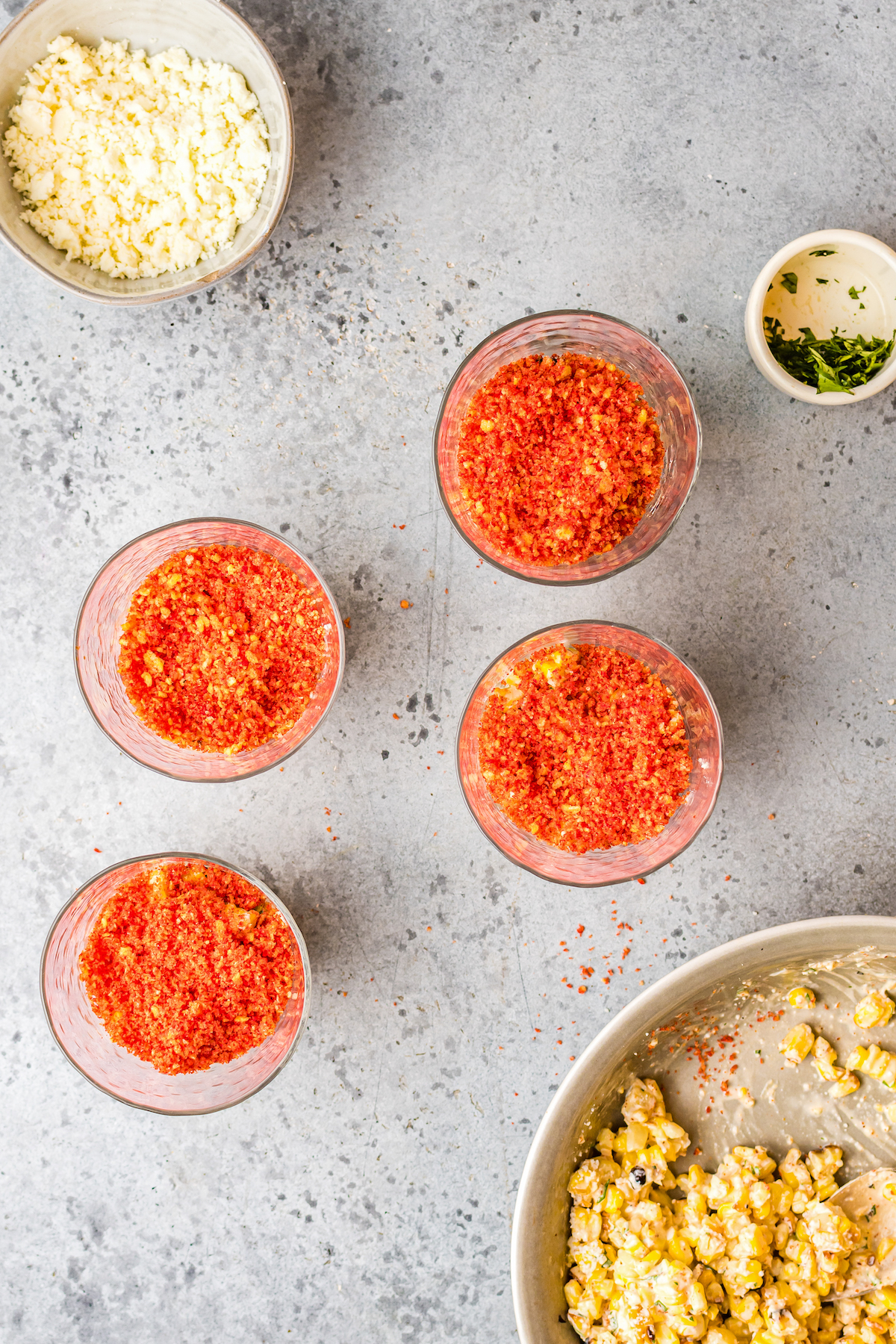 Small cups of corn salad topped with crushed hot Cheetos.