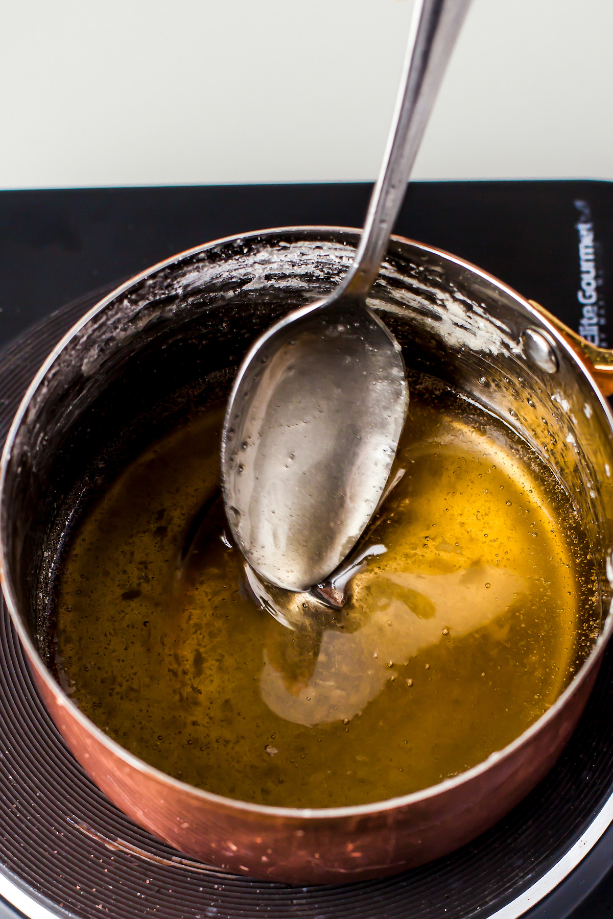 Simple syrup in a sauce pot with a spoon