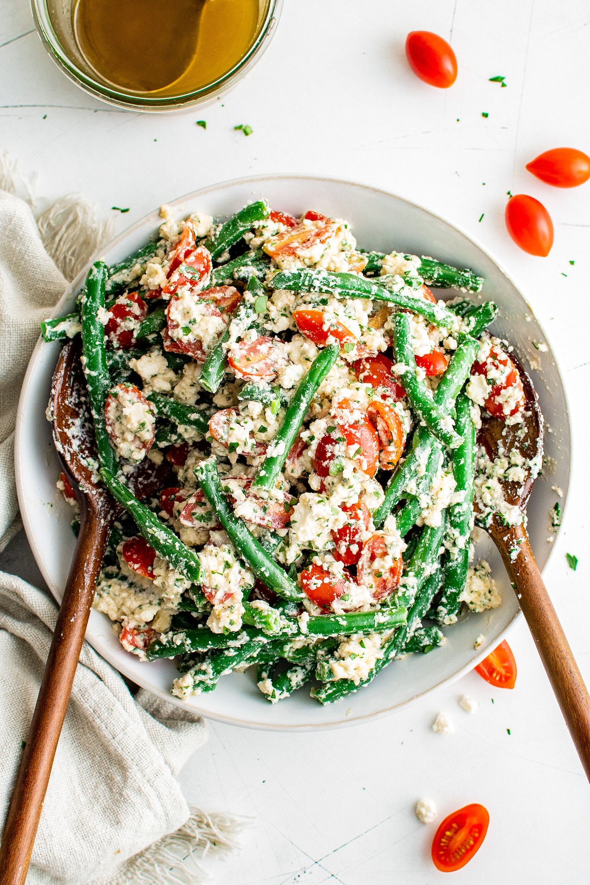 a large bowl of green bean salad with feta and grape tomatoes