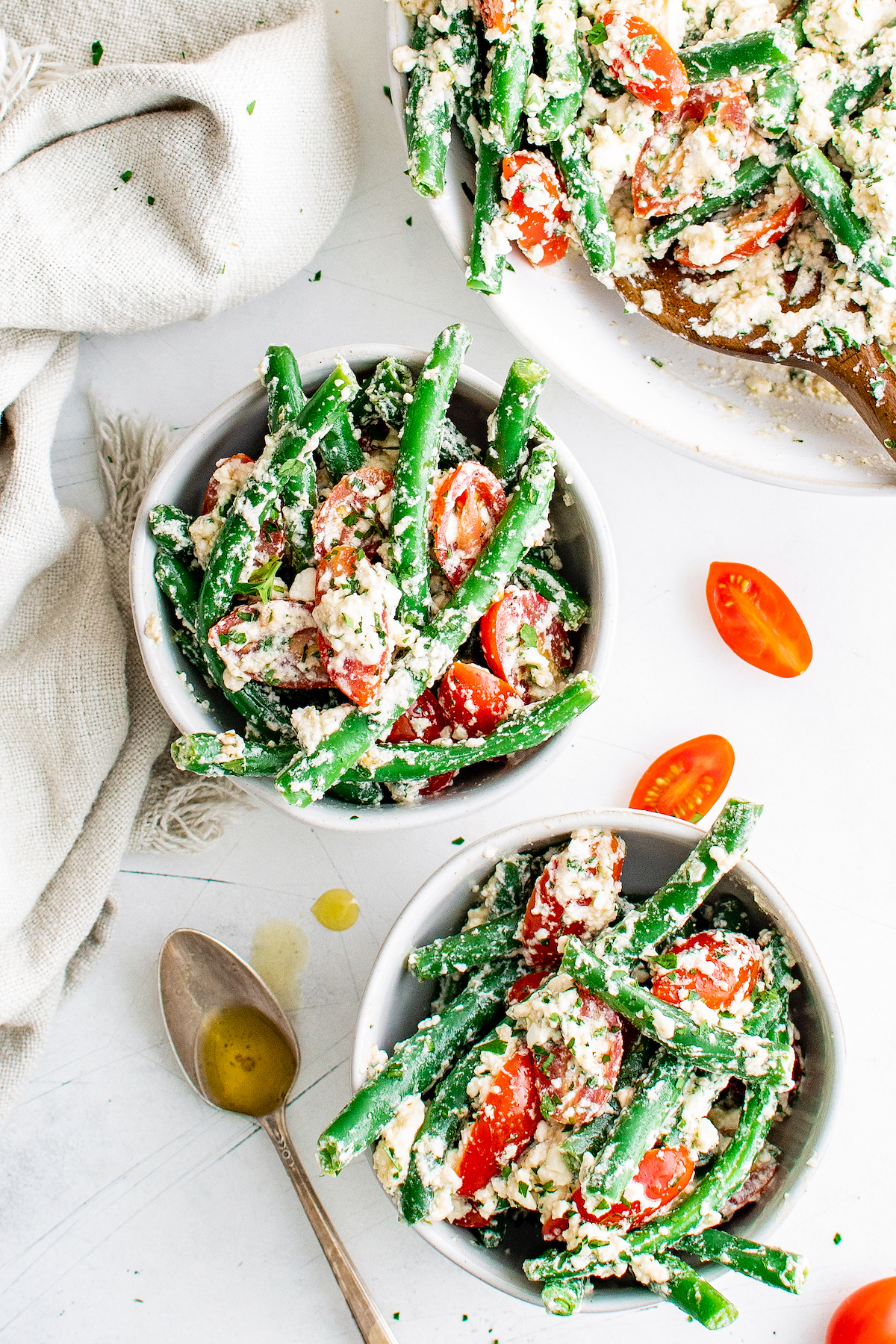 two bowls of green bean salad with grape tomatoes and feta