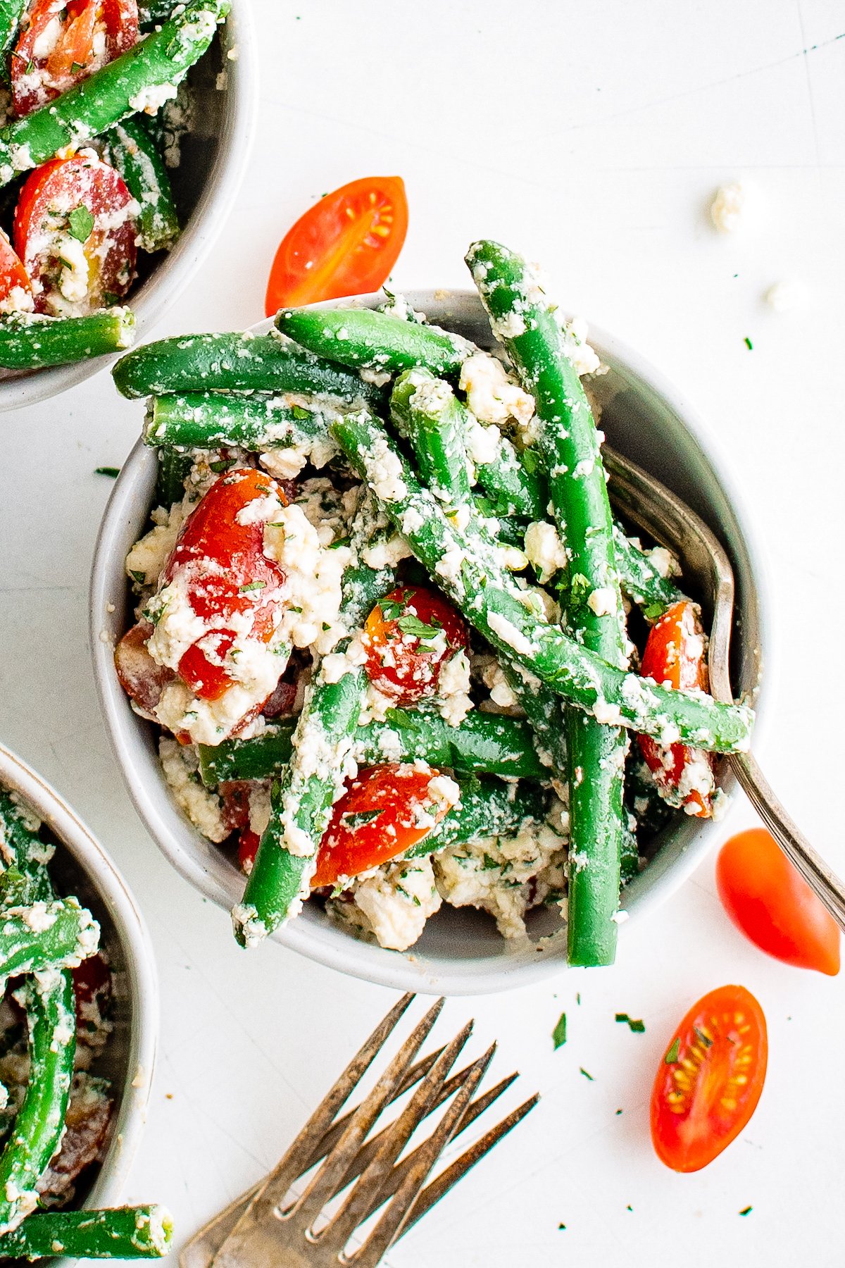 a bowl of green bean salad with grape tomatoes and feta