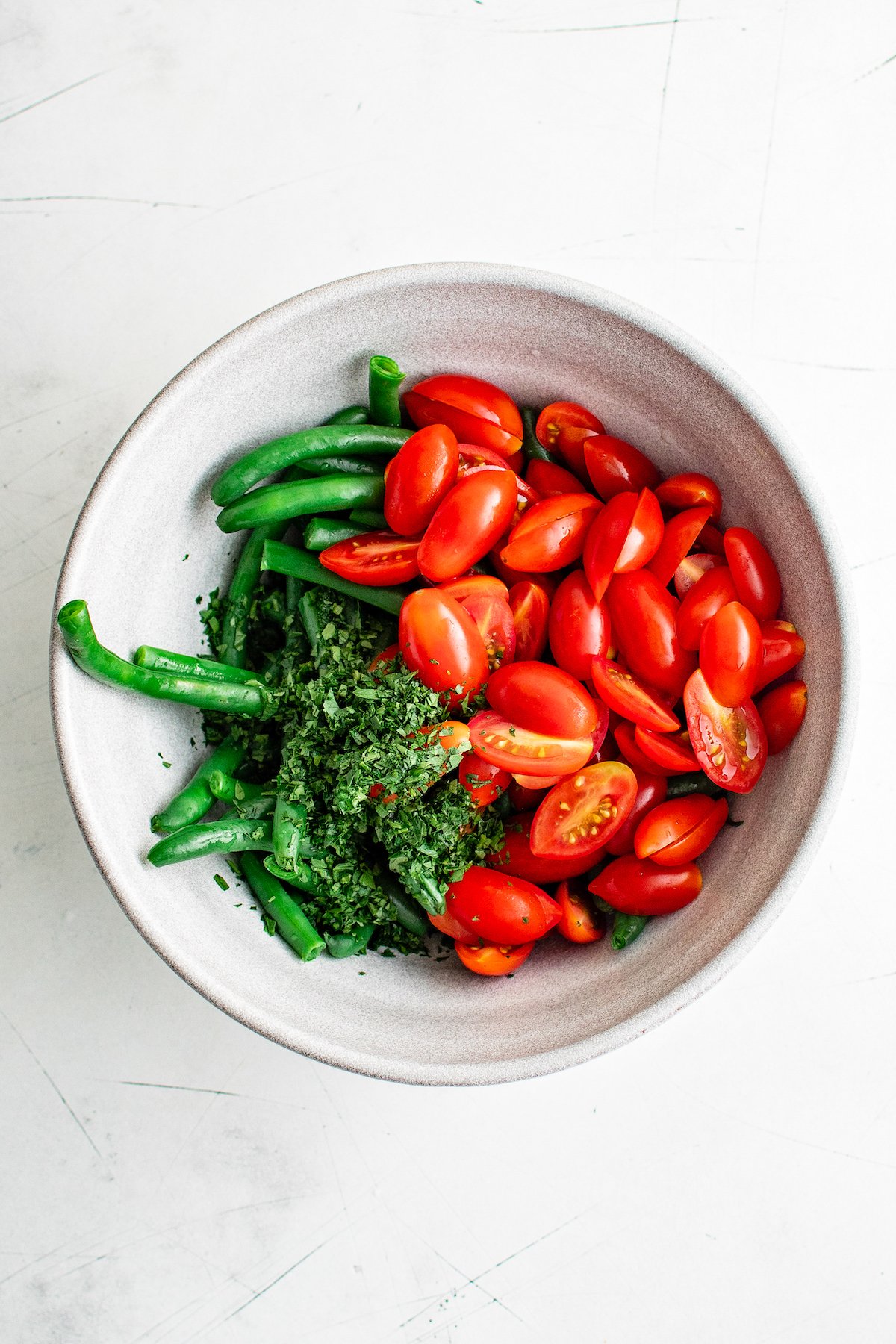 green beans, grape tomatoes, and chopped parsley in a bowl