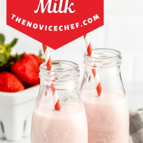 Two glasses of strawberry milk with straws on a cutting board.