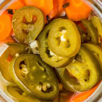 Overhead shot of a jar of pickled jalapeños and carrots.