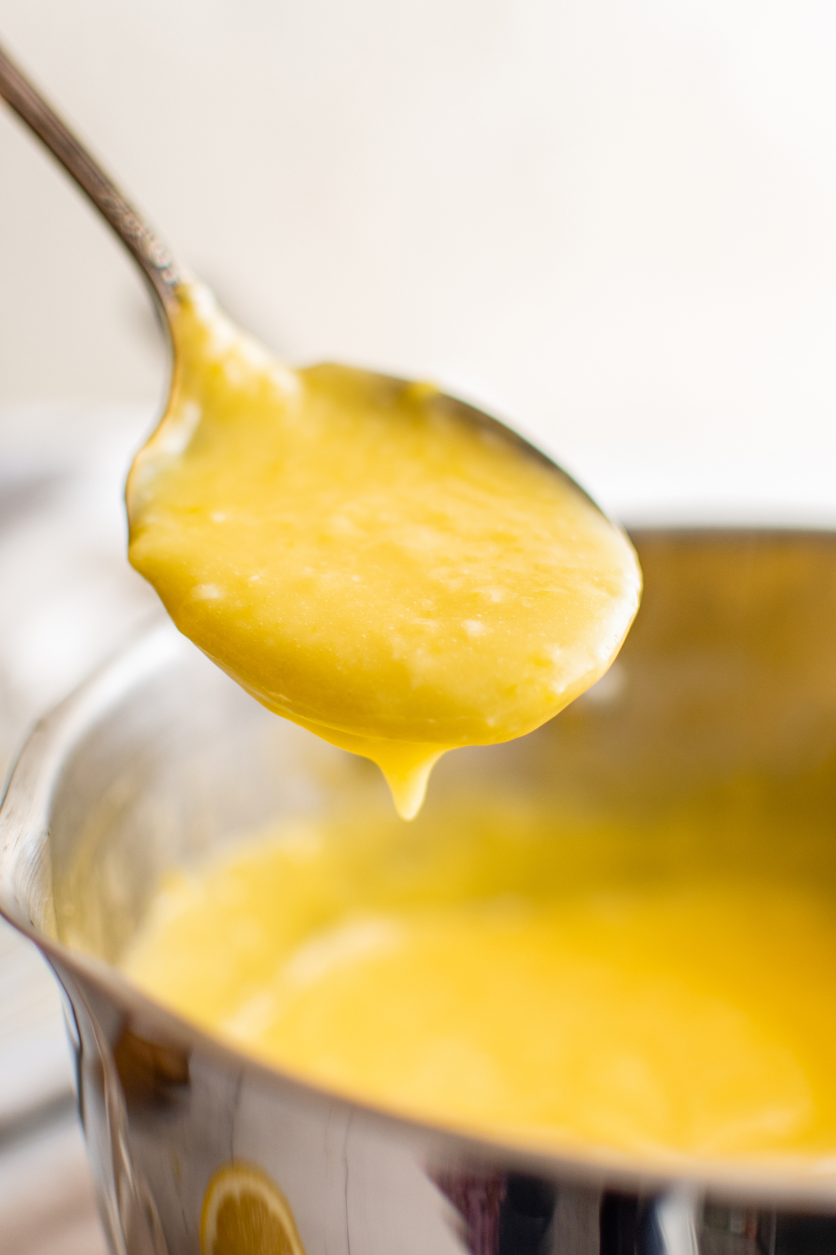 A spoonful of lemon curd from a sauce pan.