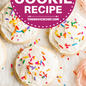 Sugar cookies with vanilla frosting and sprinkles on parchment paper.